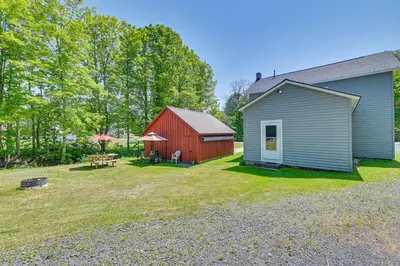 a barn and a house with a yard with a table and bench at Countryside Hideaway - 10 Mi to Cooperstown! in Westford