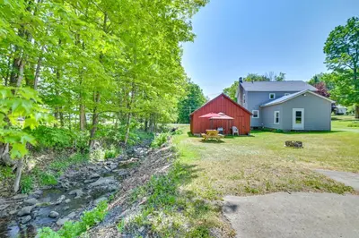 a yard with a red barn and a white house at Countryside Hideaway - 10 Mi to Cooperstown! in Westford