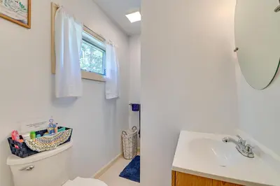 a bathroom with a toilet and a sink and a mirror at Countryside Hideaway - 10 Mi to Cooperstown! in Westford