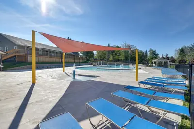 a group of blue chairs and a swimming pool at Relax Fireside! Retreat 15 Mi to Camelback Slopes in Tobyhanna