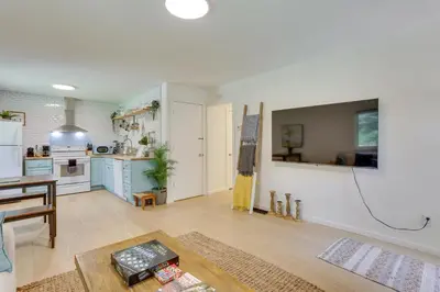 a living room with a table and a kitchen at Cozy Swan Lake Apt with Grill and Private Yard in Swan Lake
