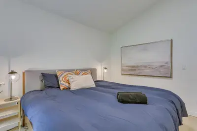 a bed with a blue comforter in a bedroom at Charming Swan Lake Apartment with Deck! in Swan Lake