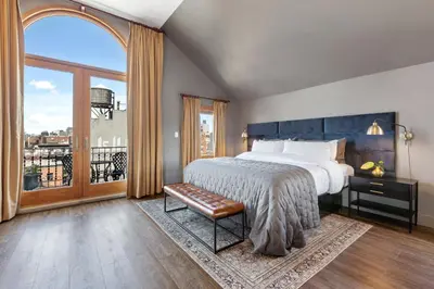 a bedroom with a large bed and a large window at The Historic Blue Moon Hotel - NYC in New York