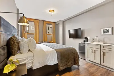 a hotel room with a bed and a kitchen at The Historic Blue Moon Hotel - NYC in New York