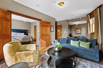 a living room with a blue couch and a bed at The Historic Blue Moon Hotel - NYC in New York