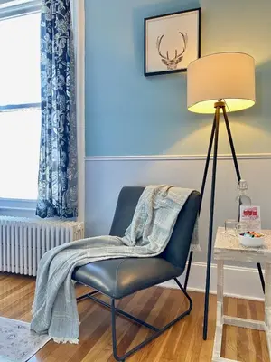 a chair with a blanket on it next to a lamp at Bloom Farm Guesthouse in Mount Vision