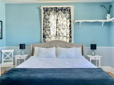 a blue bedroom with a bed and a window at Bloom Farm Guesthouse in Mount Vision