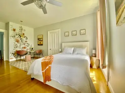 a bedroom with a large white bed and a table at Bloom Farm Guesthouse in Mount Vision