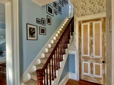 a staircase in a home with pictures on the wall at Bloom Farm Guesthouse in Mount Vision
