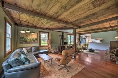 a living room with a leather couch and wooden ceilings at Game Room and Fire Pit Peaceful Catskills Farmhouse in Treadwell