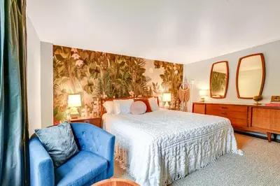 a bedroom with a bed and a blue chair at Game Room and Fire Pit Peaceful Catskills Farmhouse in Treadwell