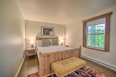 a bedroom with a wooden bed and a window at Game Room and Fire Pit Peaceful Catskills Farmhouse in Treadwell