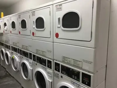 a row of white washing machines in a laundrette at Hansem stay near Empire State Building in New York