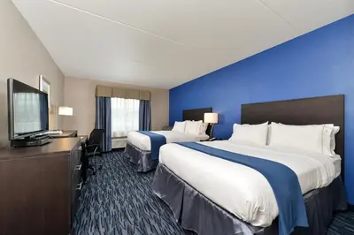 a hotel room with two beds and a flat screen tv at Holiday Inn Express & Suites Peekskill-Lower Hudson Valley by IHG in Peekskill