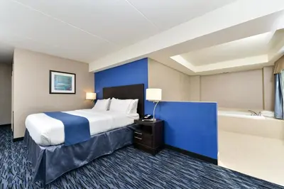 a hotel room with a bed and a bath tub at Holiday Inn Express & Suites Peekskill-Lower Hudson Valley by IHG in Peekskill