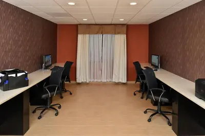 a conference room with desks and chairs and a window at Holiday Inn Express & Suites Peekskill-Lower Hudson Valley by IHG in Peekskill