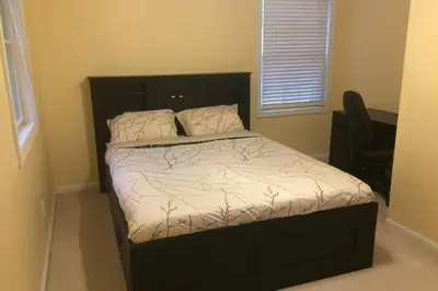a bedroom with a bed with a black headboard at Large family house on the lake in Hewitt