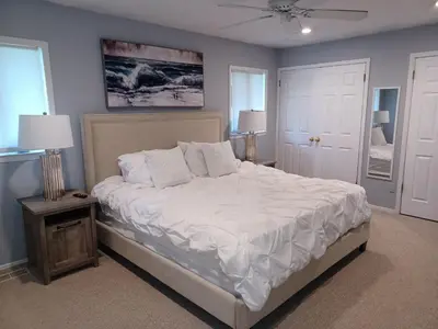 a bedroom with a large bed with white sheets and pillows at Cozy 4BR 3BA Home- Train to NYC, USOpen, CitiField Mets, MSG, Walk to Harbor & Golf in Port Washington