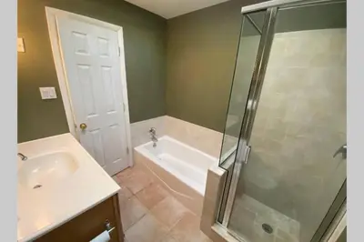 a bathroom with a shower and a sink and a tub at Cozy 4BR 3BA Home- Train to NYC, USOpen, CitiField Mets, MSG, Walk to Harbor & Golf in Port Washington