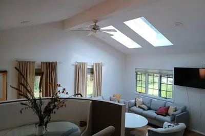 a living room with a couch and a ceiling fan at Cozy 4BR 3BA Home- Train to NYC, USOpen, CitiField Mets, MSG, Walk to Harbor & Golf in Port Washington