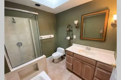 a bathroom with a sink and a shower and a toilet at Cozy 4BR 3BA Home- Train to NYC, USOpen, CitiField Mets, MSG, Walk to Harbor & Golf in Port Washington