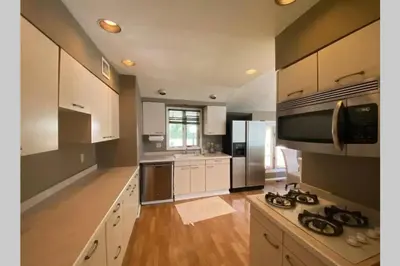 a kitchen with white cabinets and a stove top oven at Cozy 4BR 3BA Home- Train to NYC, USOpen, CitiField Mets, MSG, Walk to Harbor & Golf in Port Washington