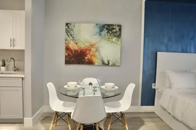 a dining room with a table and chairs and a bed at Global Luxury Suites at The Arches in Bronx