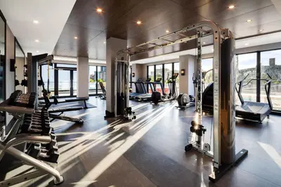 a gym with treadmills and machines in a room at Global Luxury Suites at The Arches in Bronx
