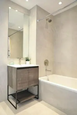 a bathroom with a sink and a tub and a mirror at Global Luxury Suites at The Arches in Bronx