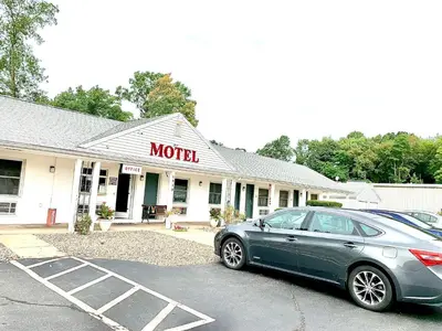 a car parked in a parking lot in front of a motel at Nitey Nite Motel in South Windsor