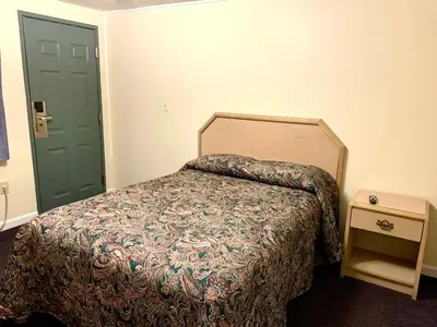 a bedroom with a bed and a green door at Nitey Nite Motel in South Windsor