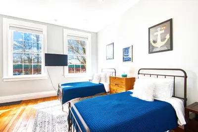 a bedroom with two beds and two windows at Hudson Mariner in Hudson