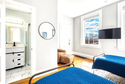 a bedroom with a blue bed and a mirror at Hudson Mariner in Hudson