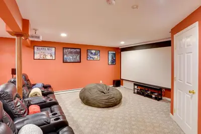 a living room with a couch and a screen at Expansive Upstate Home with Home Theater! in East Schodack