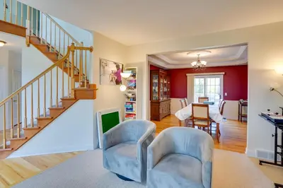 a living room with a staircase and chairs at Expansive Upstate Home with Home Theater! in East Schodack
