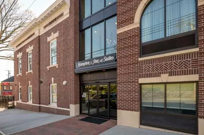 a brick building with a sign on it at Hampton Inn & Suites Huntington Downtown, Ny in Huntington