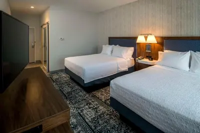a hotel room with two beds and a television at Hampton Inn & Suites Huntington Downtown, Ny in Huntington