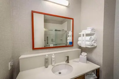 a bathroom with a sink and a mirror at Hampton Inn & Suites Huntington Downtown, Ny in Huntington