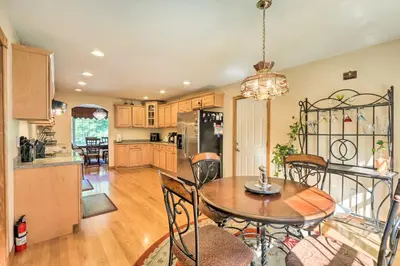 a kitchen and dining room with a table and chairs at Granby Home with Deck Less Than half Mi to Aldrich Lake! in Granby