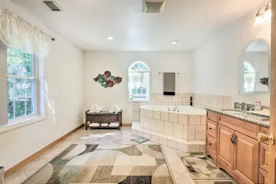 a large bathroom with a tub and a sink at Granby Home with Deck Less Than half Mi to Aldrich Lake! in Granby