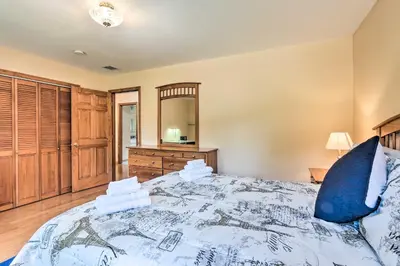a bedroom with a large bed with a blue pillow at Granby Home with Deck Less Than half Mi to Aldrich Lake! in Granby