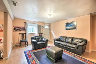 a living room with a leather couch and a chair at Granby Home with Deck Less Than half Mi to Aldrich Lake! in Granby