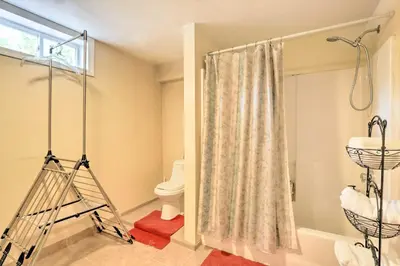 a bathroom with a shower curtain and a toilet at Granby Home with Deck Less Than half Mi to Aldrich Lake! in Granby