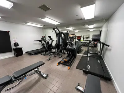 a gym with several treadmills and exercise bikes at National at 888 Sixth Avenue - Furnished Apartments in New York