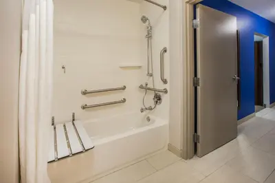 a bathroom with a bath tub with a shower curtain at Holiday Inn Express - New Rochelle by IHG in New Rochelle