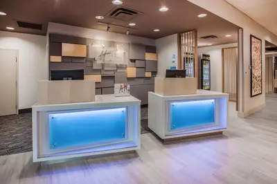an office lobby with two counters with blue screens at Holiday Inn Express - New Rochelle by IHG in New Rochelle