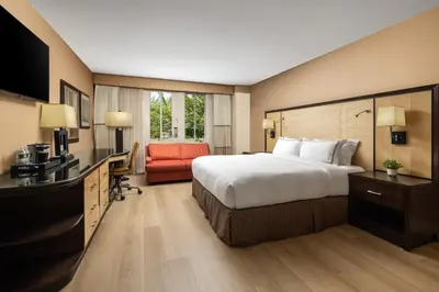 a hotel room with a large bed and a desk at Sleepy Hollow Hotel in Tarrytown