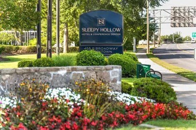 a sign for the city of sleepy hollow with flowers at Sleepy Hollow Hotel in Tarrytown