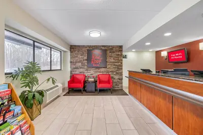 a waiting room at a fast food restaurant with red chairs at Red Roof Inn Parsippany in Parsippany