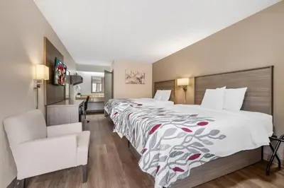 a hotel room with a large bed and a chair at Red Roof Inn Parsippany in Parsippany